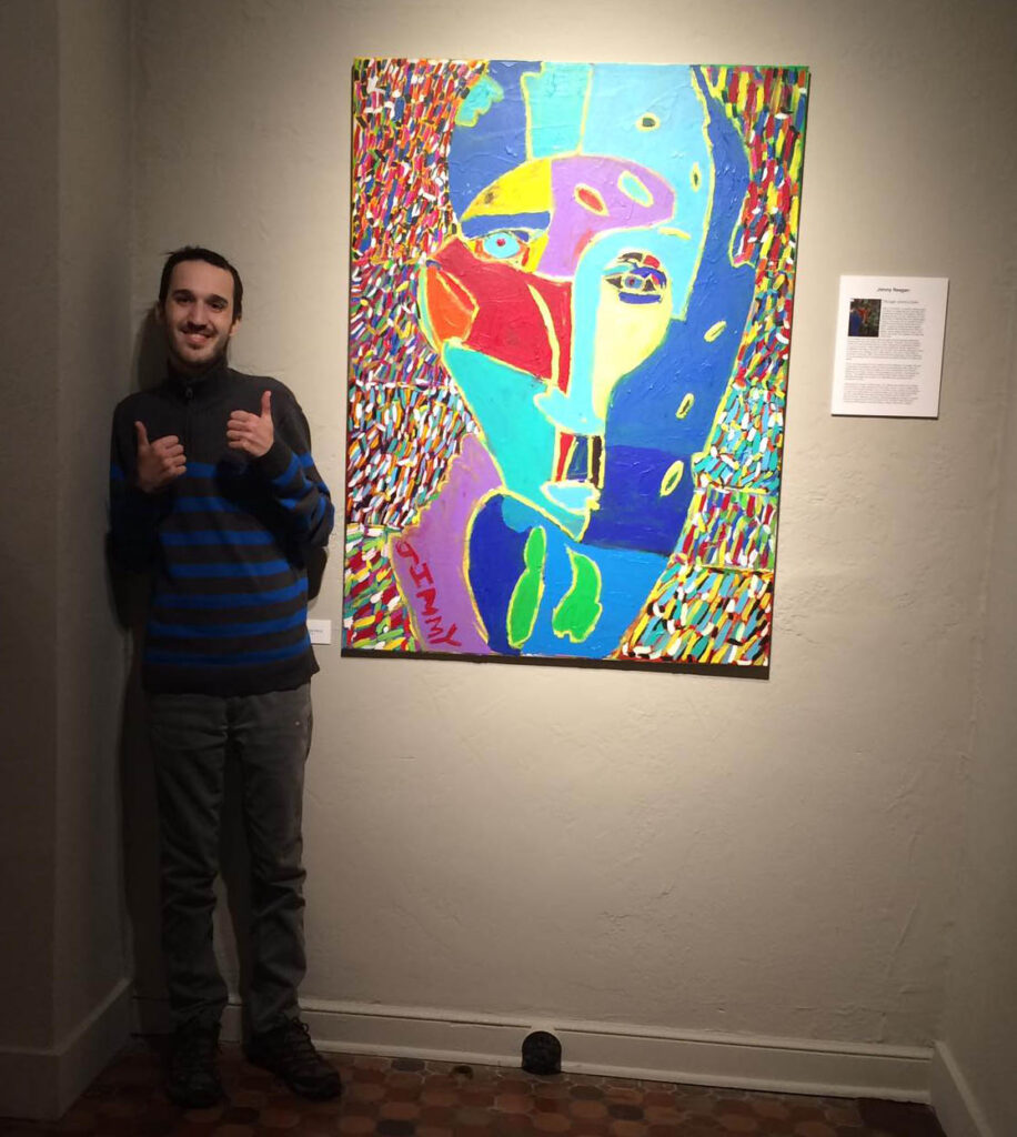 Jimmy Reagan giving thumbs up in front of his painting
