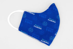 fabric face mask with "wearing is caring" print, side view
