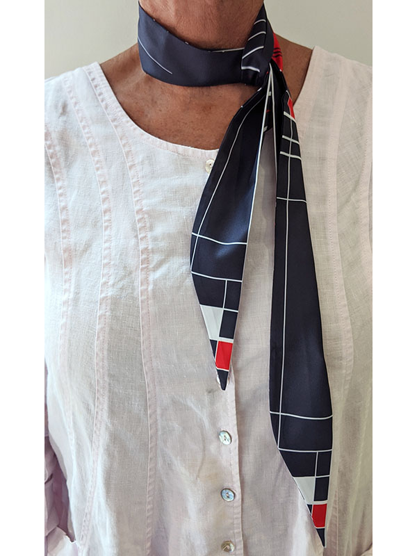 person wearing a custom navy twilly scarf with geometric design