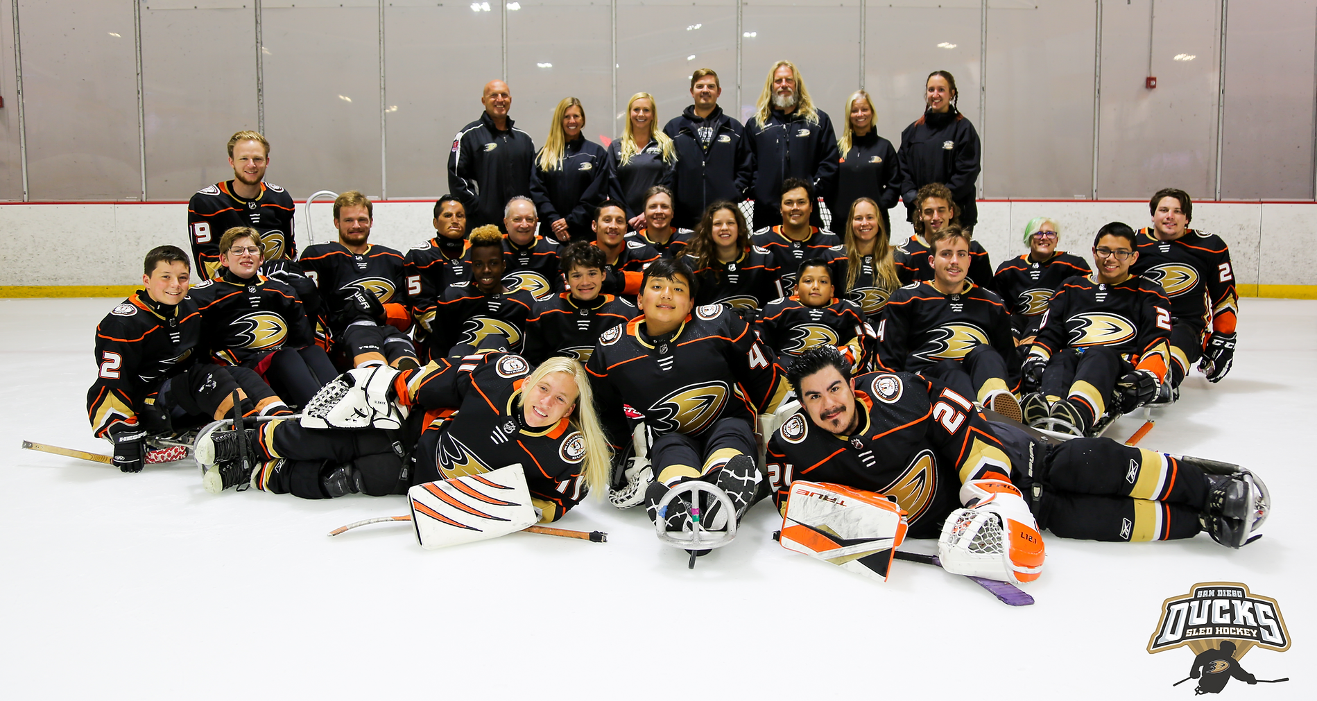 The San Diego Ducks Sled Hockey team poses for a team picture on the ice. 