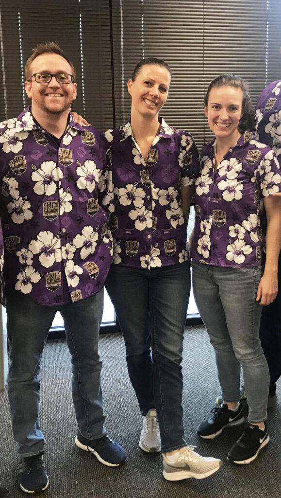Photo of three employees wearing purple custom Hawaiian shirts
