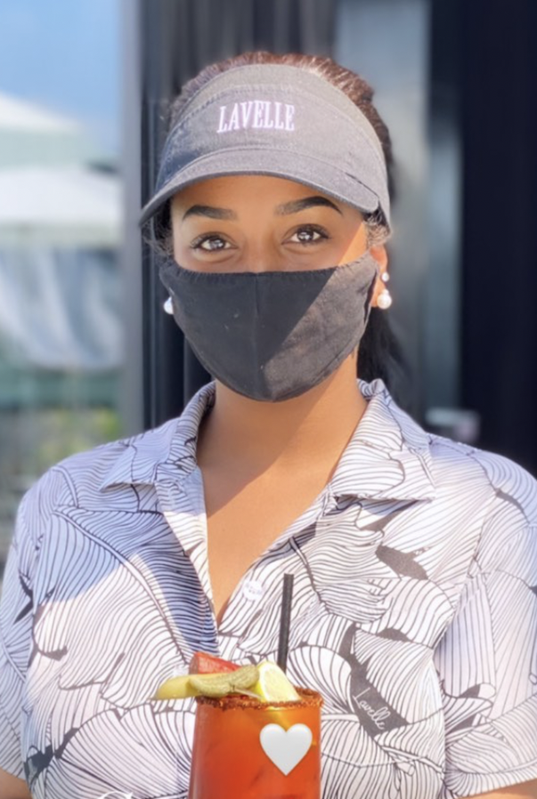 A masked restaurant worker in a custom Hawaiian shirt