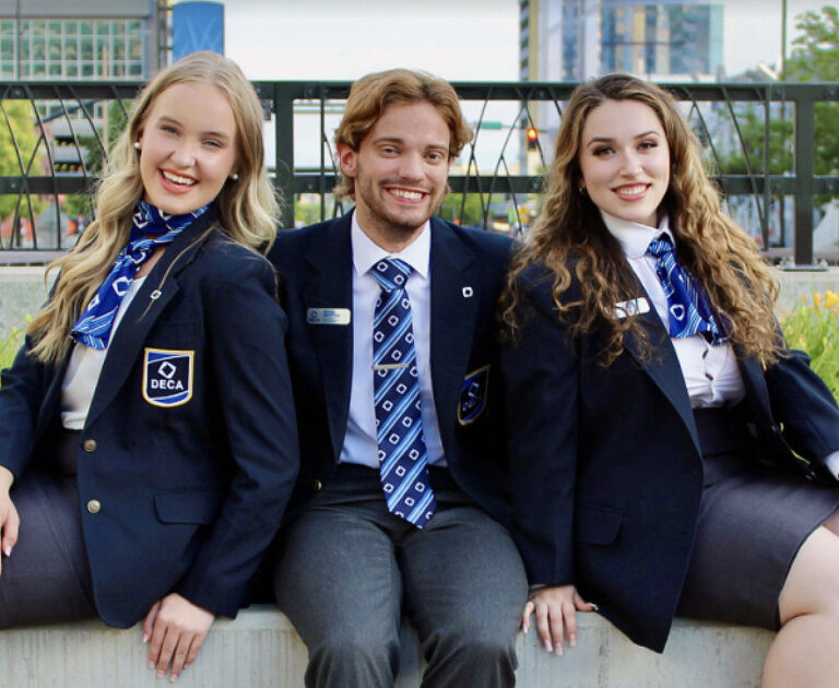 Photo of three people wearing DECA ties and scarves