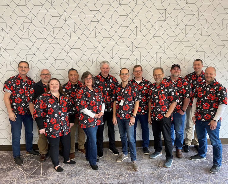 Group photo of Holman Logistics team wearing custom Hawaiian shirts