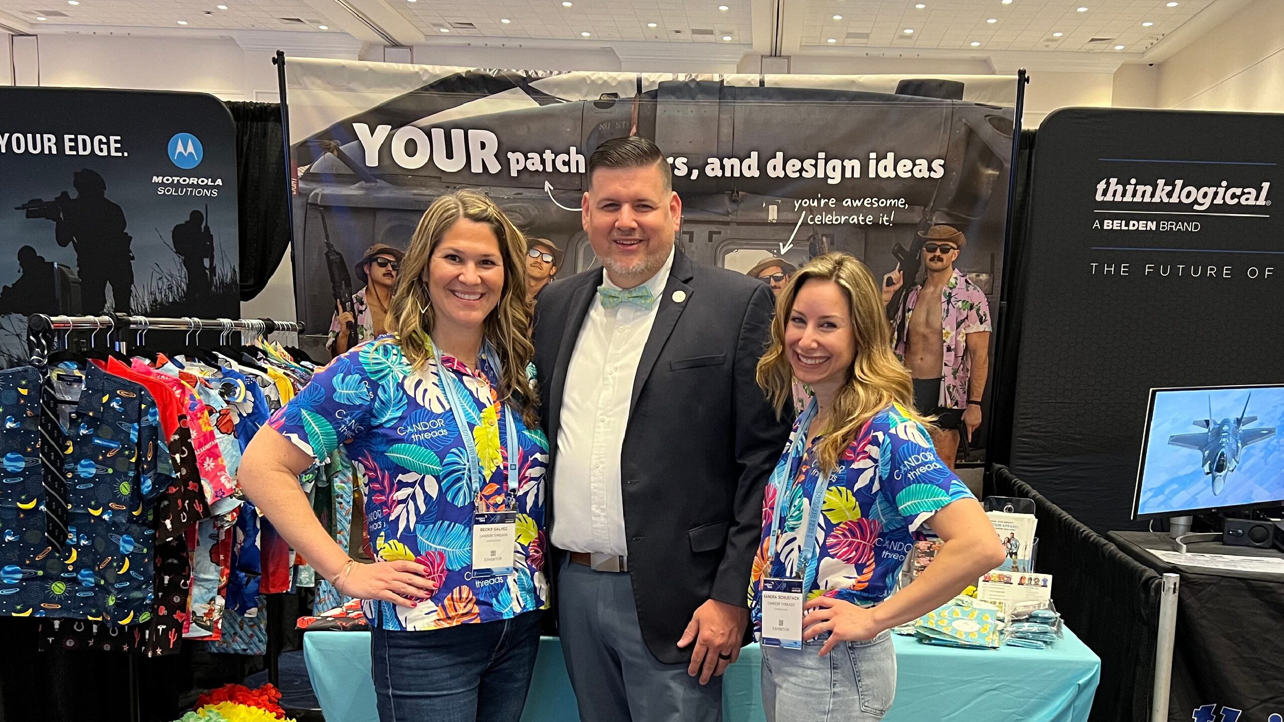 A photo of Becky and Sandra standing with an attendee at our Sea Air Space booth.