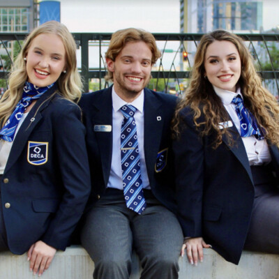 Photo of three people wearing DECA ties and scarves