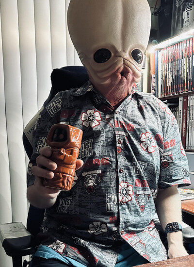 "We DID get our shirts and the reviews have been absolutely positive!
We *love* them! They are absolutely fantastic!
Since we are a Star Wars group, I *had* to try it on with one of my masks! :)
Thanks again for the fantastic help and the tremendous patience with us. I know it wasn’t the biggest order ever, but we absolutely love them!" Member of the 501st Legion wearing costume mask and custom Hawaiian shirt