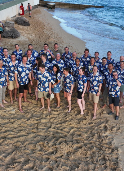 "We were in Honolulu. We had a lot of meetings with the military base there all day, but then had the evenings to enjoy. Ended up being an amazing work trip, no complaints. And everyone loved the shirts, which made it even better." Group photo of SAASS team wearing custom Hawaiian shirts